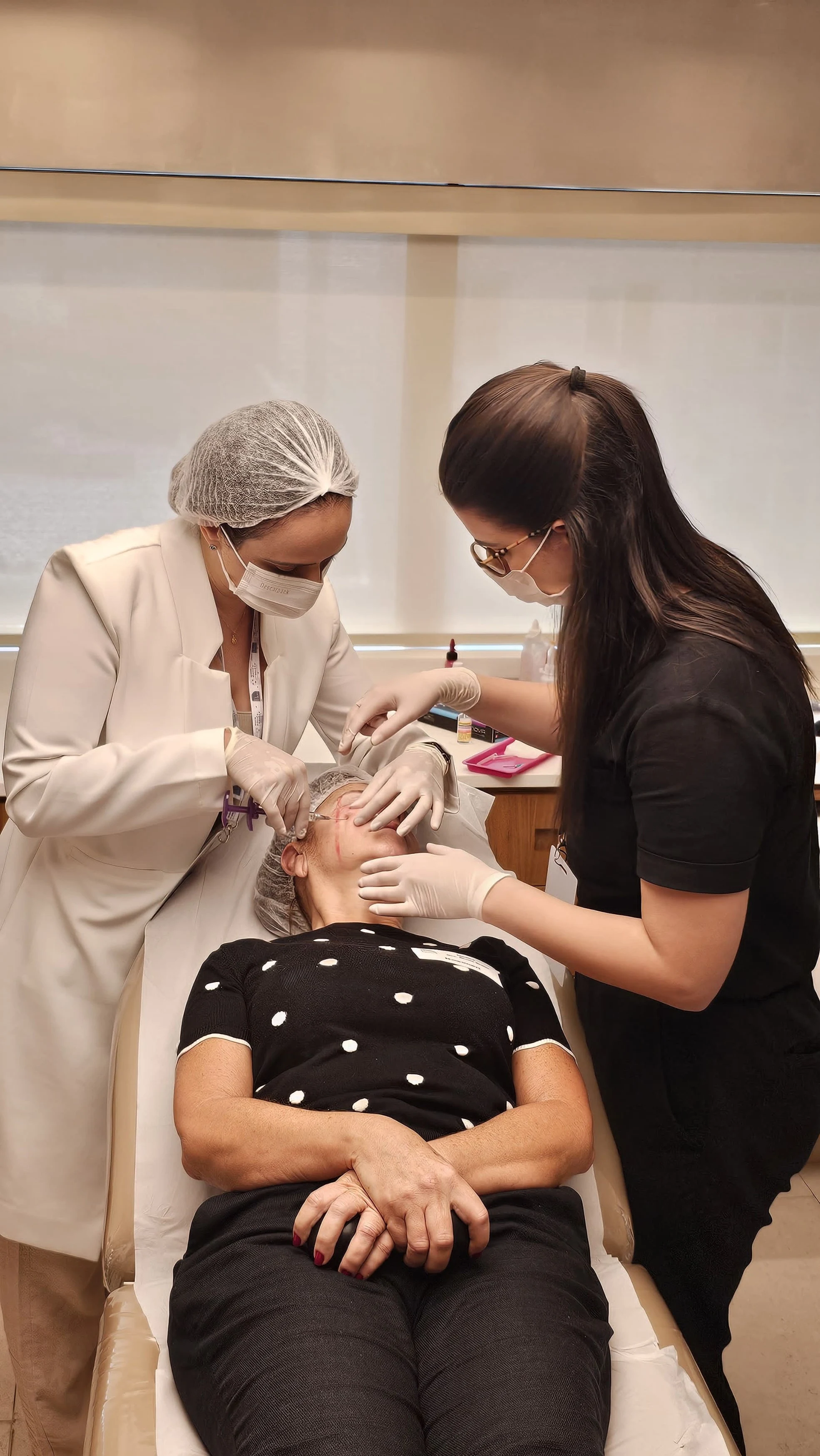 Aluna da Bravo Academy realizando procedimento em paciente-modelo com supervisão de professora durante o Injection Day